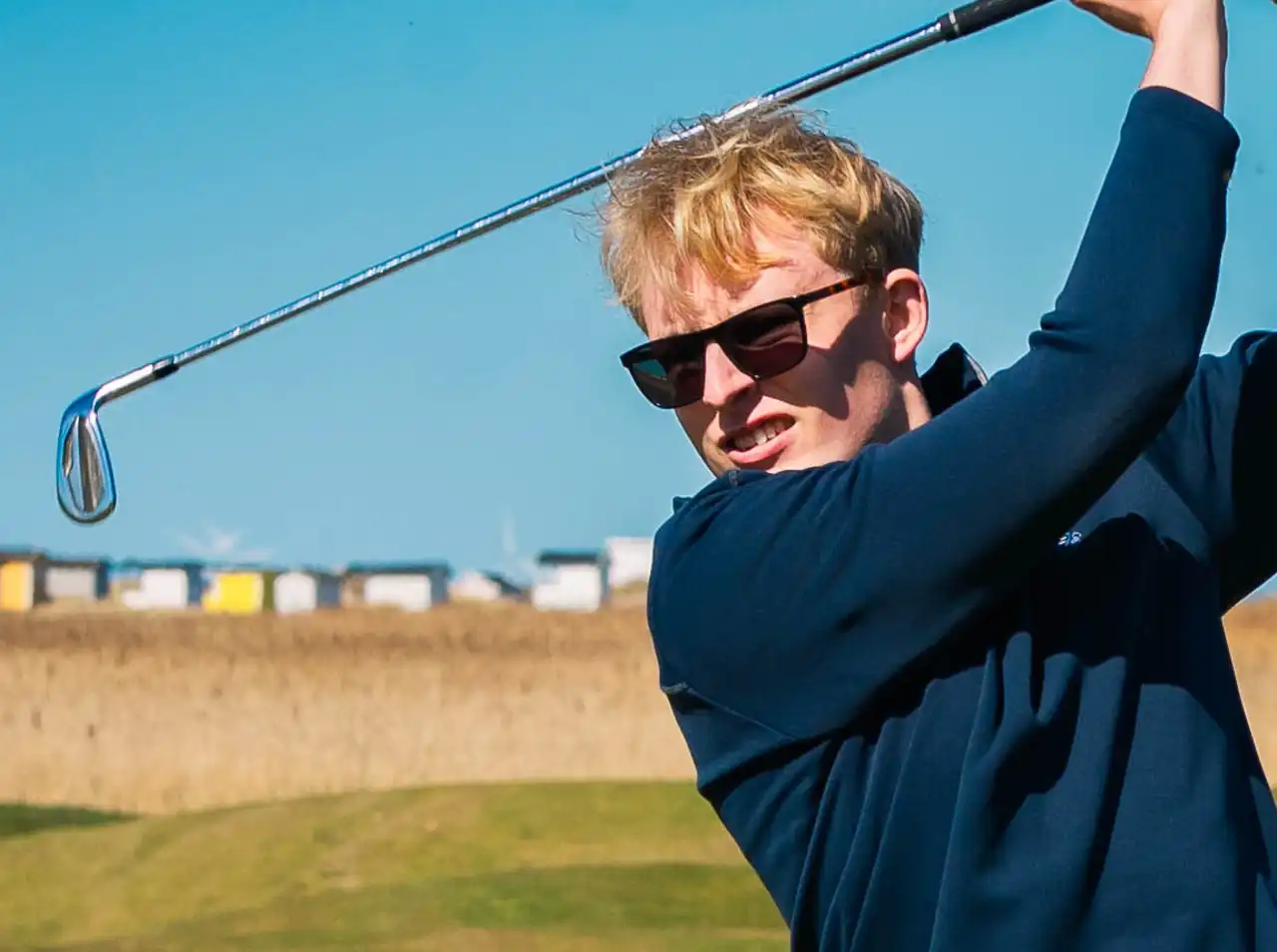 A golfer at the top of the backswing, seen from the front, on a coastal course, Falsterbo Golfklubb, (Falsterbo GK)
